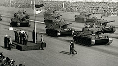 Schwarz-weiß-Fotografie einer Truppenparade mit Panzern
