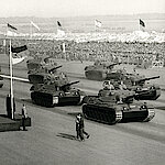 Schwarz-weiß-Fotografie einer Truppenparade mit Panzern