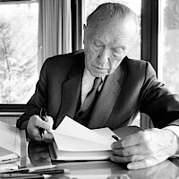 Konrad Adenauer sitzt am Schreibtisch und liest Akten