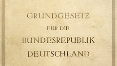 Faksimile der Urschrift des Grundgesetzes. Ein in helles Leder eingebundenes Buch mit goldener Prägung.