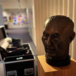 Eine Büste von Konrad Adenauer, im Hintergrund ein geöffneter Koffer, während des Aufbaus der Ausstellung