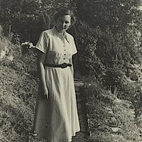 Eine junge Frau steht in einem Garten