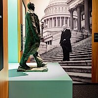 kleine Adenauer-Statue vor einem Großfoto, das Adenauer vor dem Capitol in Washington zeigt