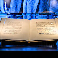 Ausstellungsvitrine mit einem aufgeklapptem Buch (Grundgesetz)