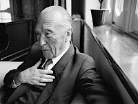 Konrad Adenauer sitzt auf einem Sessel am Fenster seines Hauses