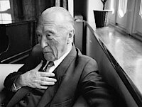 Konrad Adenauer sitzt auf einem Sessel am Fenster seines Hauses