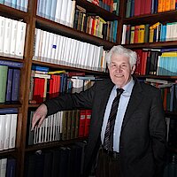 Ein Mann steht vor einem Bücherregal
