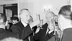 Konrad Adenauer, Ludwig Erhard und andere stoßen mit Sektgläsern an.