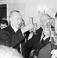 Konrad Adenauer, Ludwig Erhard und andere stoßen mit Sektgläsern an.